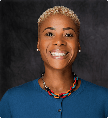 Portrait of a smiling black woman wearing a blue shirt and necklace, the founder of Nclusive Scan.